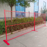 Installed red temporary fence in front of a building, demonstrating its functionality for boundary setting and event management.