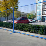 Blue powder-coated temporary construction fence in a Canadian urban setting, highlighting the use of durable materials and compliance with height and opening regulations for construction site safety.