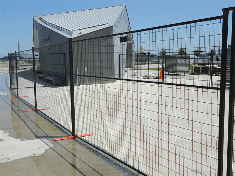 Temporary fence panels installed around a modern building.