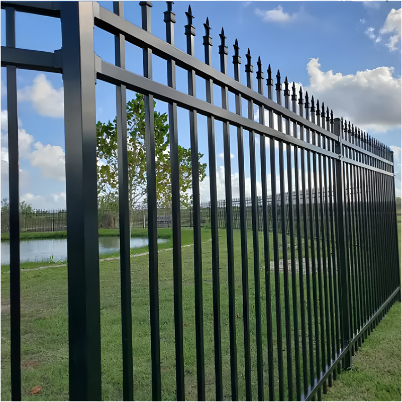 Black security fence panels with spear tops surrounding a landscaped area, showcasing durability and aesthetic appeal.