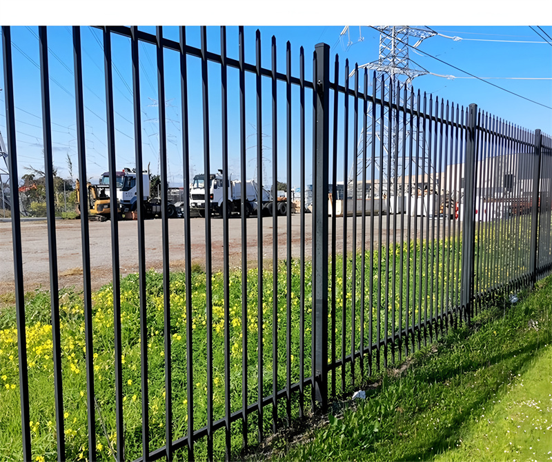 Black metal fence providing security around a commercial property.