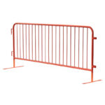 A red metal safety barrier with vertical bars, designed to control crowds and define boundaries at events.