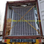 A shipping container filled with tightly packed metal grids and accessories, secured with straps to prevent movement during transport.