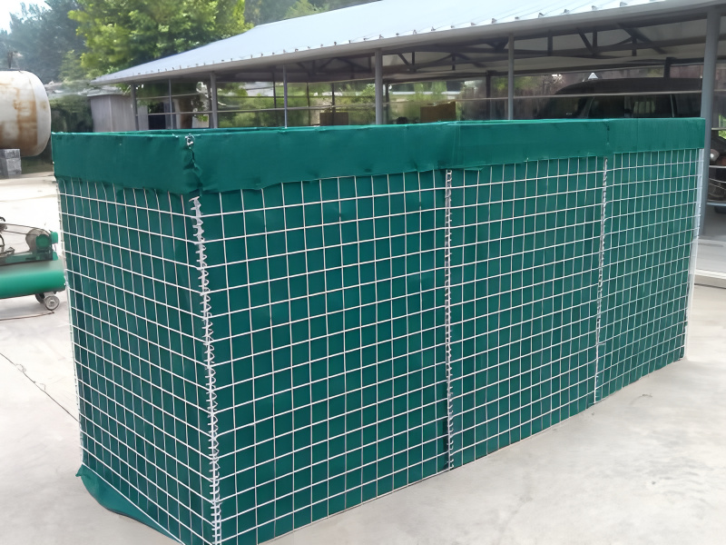 A fully assembled wire mesh barrier with a green fabric lining, set up outdoors on a concrete surface.