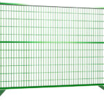 A green construction fence displayed against a plain background, featuring a grid design and sturdy base supports.