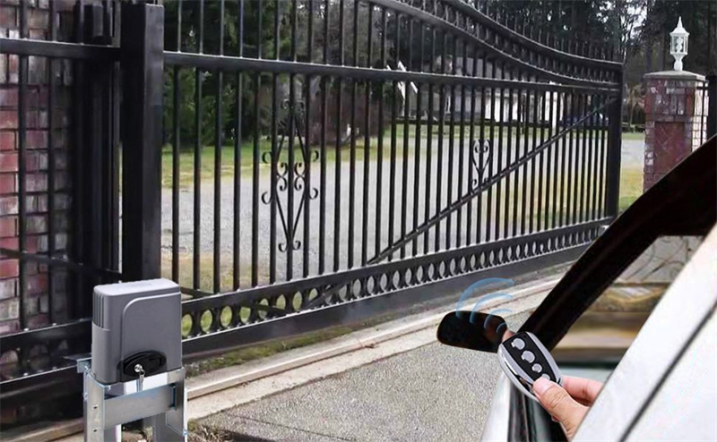 Automated black ornate sliding gate being operated by a car remote control, showcasing convenient access and an external gate motor for residential or commercial use.