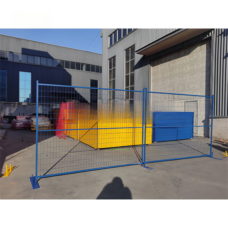 Blue temporary fencing panels installed outside industrial building with metal bases for construction site security