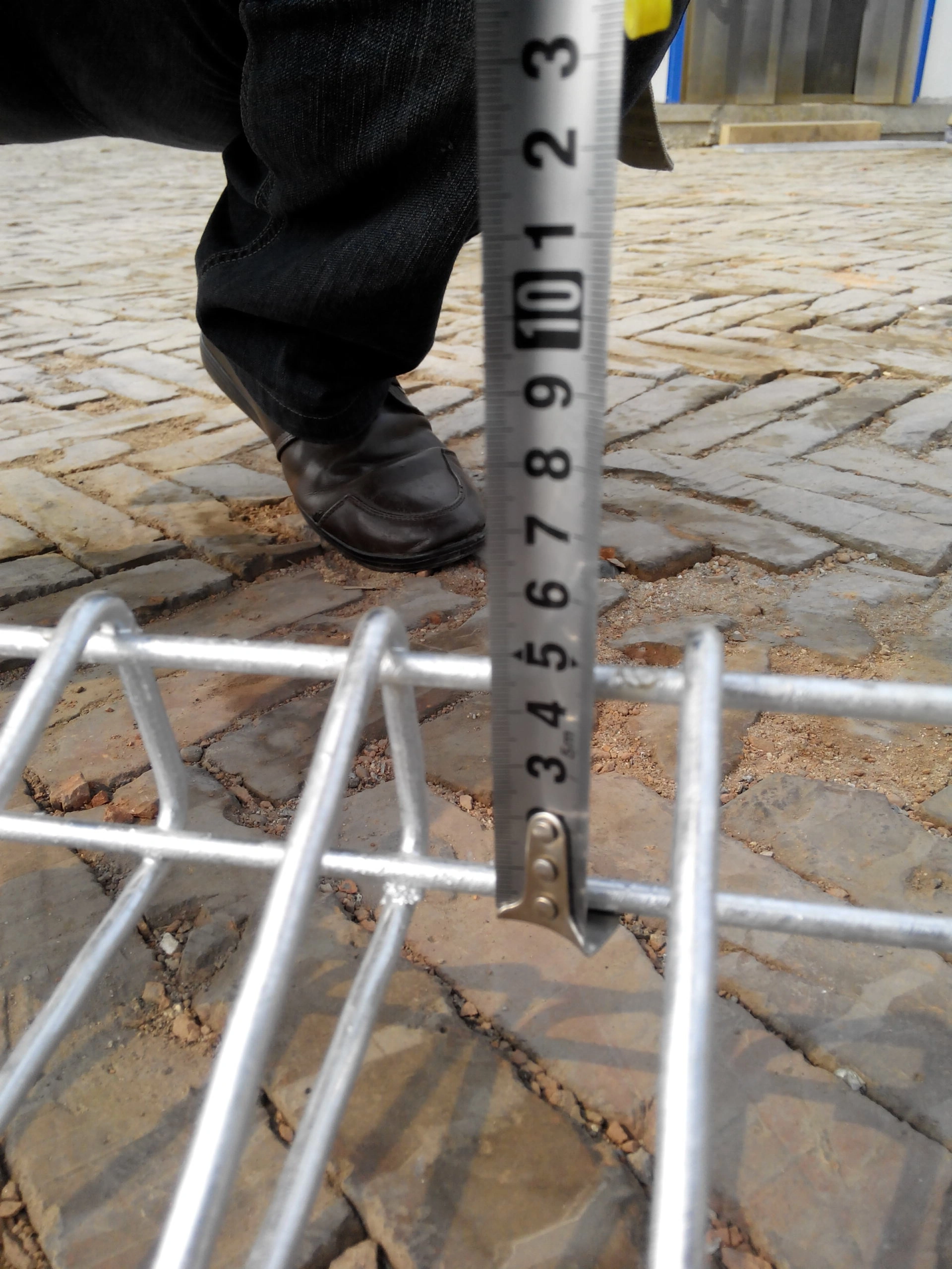 A BRC wire mesh fence being measured with a tape measure to verify height, showcasing DB Fencing's commitment to AS 4687-compliant quality control for durable, outdoor-ready fencing used by construction firms and event organizers.