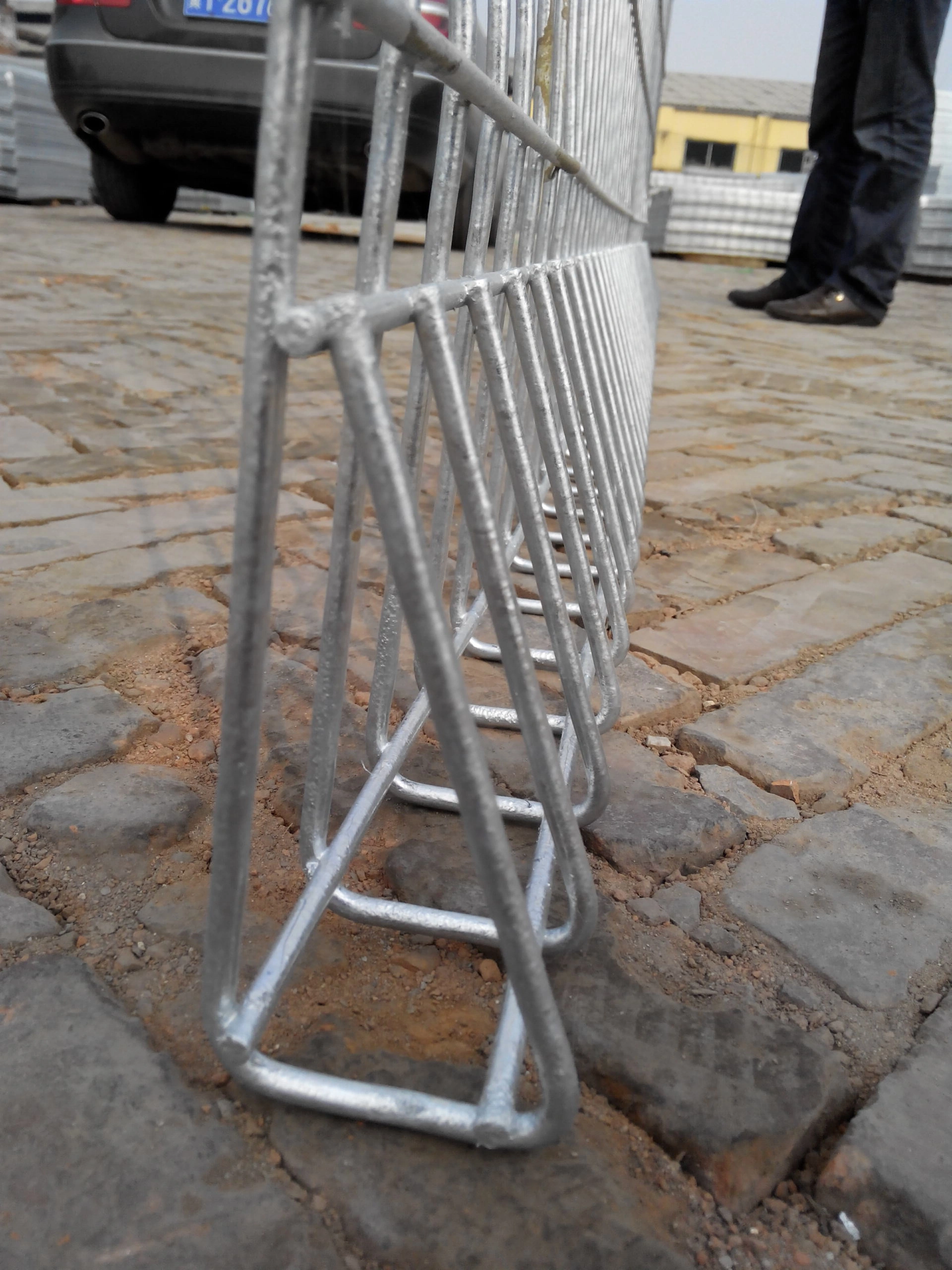 Close-up of DB Fencing's galvanized BRC mesh fence panel with triangular base, designed for temporary security at construction sites and public events, featuring hot-dipped galvanized finish for long-lasting outdoor durability.