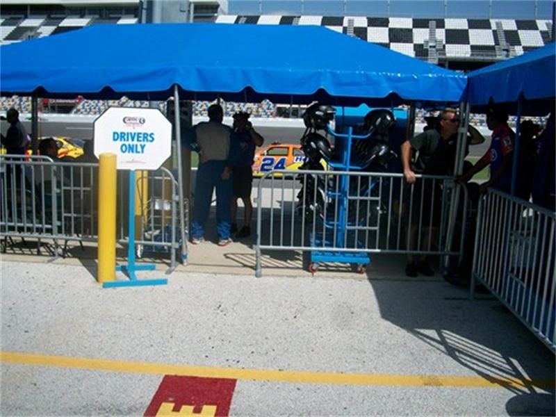 Metal crowd control barriers from DB Fencing secure the pit area at a race event, showcasing their durability and effectiveness in temporary site security for high-traffic events.