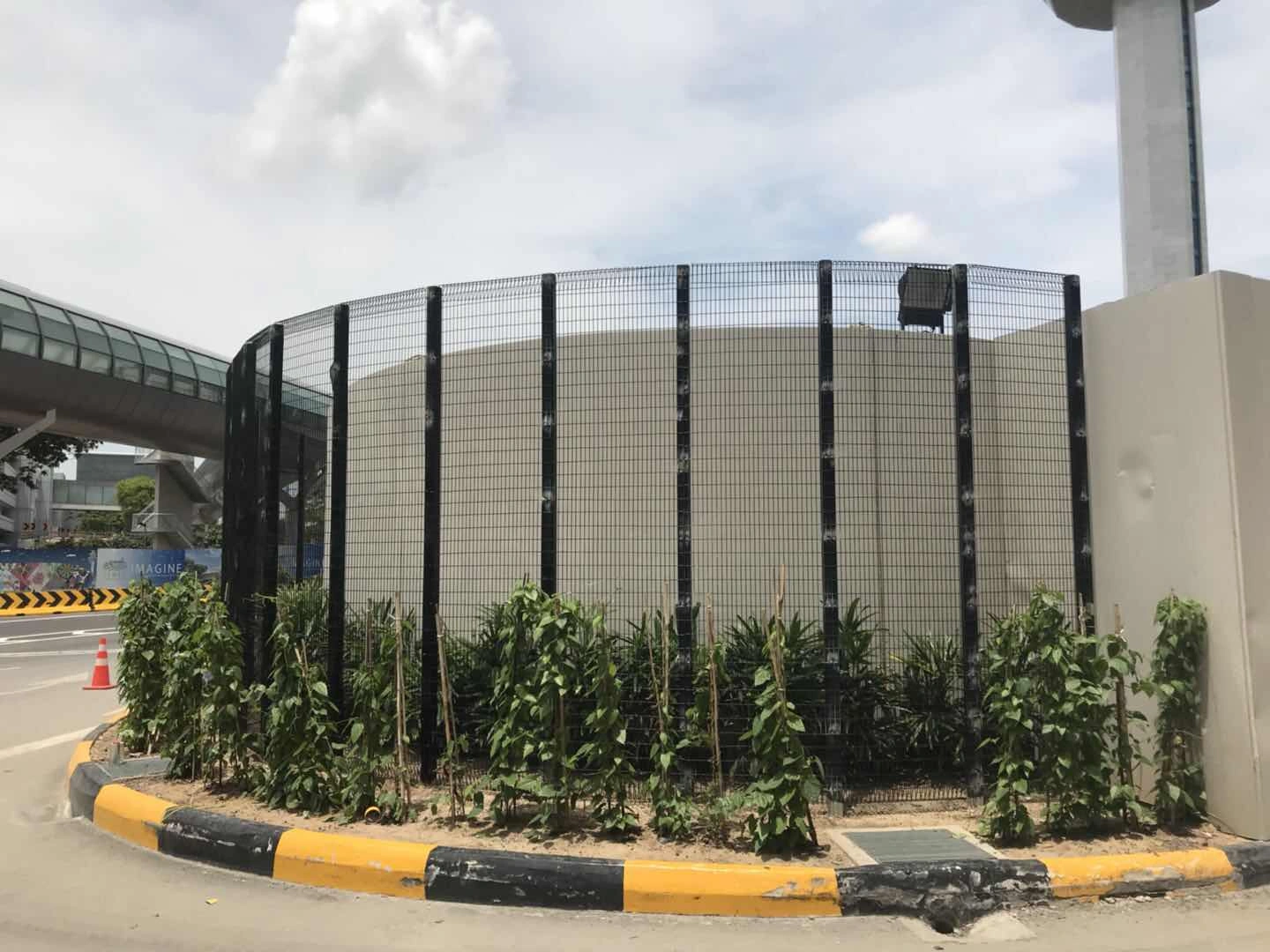 Curved temporary site security anti-climb mesh fence by DB Fencing, featuring vertical posts and durable hot-dipped galvanized finish, installed around a concrete structure for construction site protection.