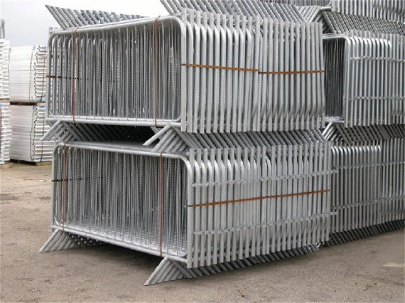 Stacked galvanized crowd control barriers from DB Fencing, a leading one-stop wire mesh fence manufacturer, showcasing bulk storage of temporary fencing designed for construction firms and event management companies.