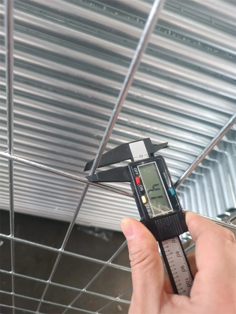 A hand uses a digital caliper to measure the wire diameter of DB Fencing's hot-dipped galvanized temporary fence mesh, showcasing the company's rigorous quality control process for AS 4687-2022 compliant products.
