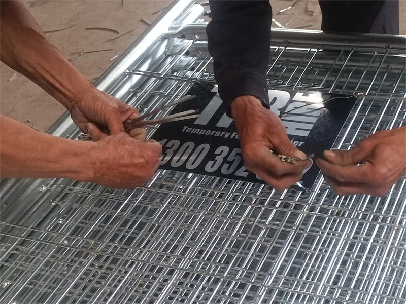 Hands assembling a galvanized temporary fence wire mesh panel, showcasing DB Fencing's manufacturing expertise in producing durable, AS4687-compliant temporary fencing for construction and event management applications.
