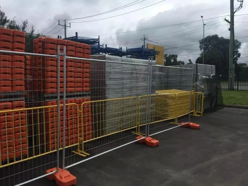 DB Fencing's temporary metal fence systems with orange plastic feet, manufactured in Anping, China, featuring hot-dipped galvanized finishes and designed for construction site security and event crowd control.
