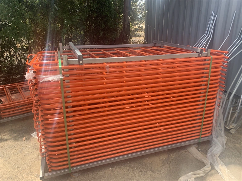 Stack of orange metal crowd control barriers manufactured by DB Fencing, a leading wire mesh fence producer with 14 years of export experience, designed for temporary site security and event management applications.