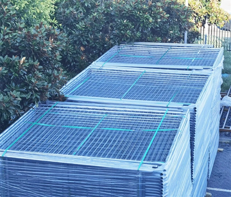 Stacked galvanized temporary fence panels wrapped in plastic with green straps, showcasing DB Fencing’s durable, bulk-packaged solutions for construction sites, events, and agricultural use.