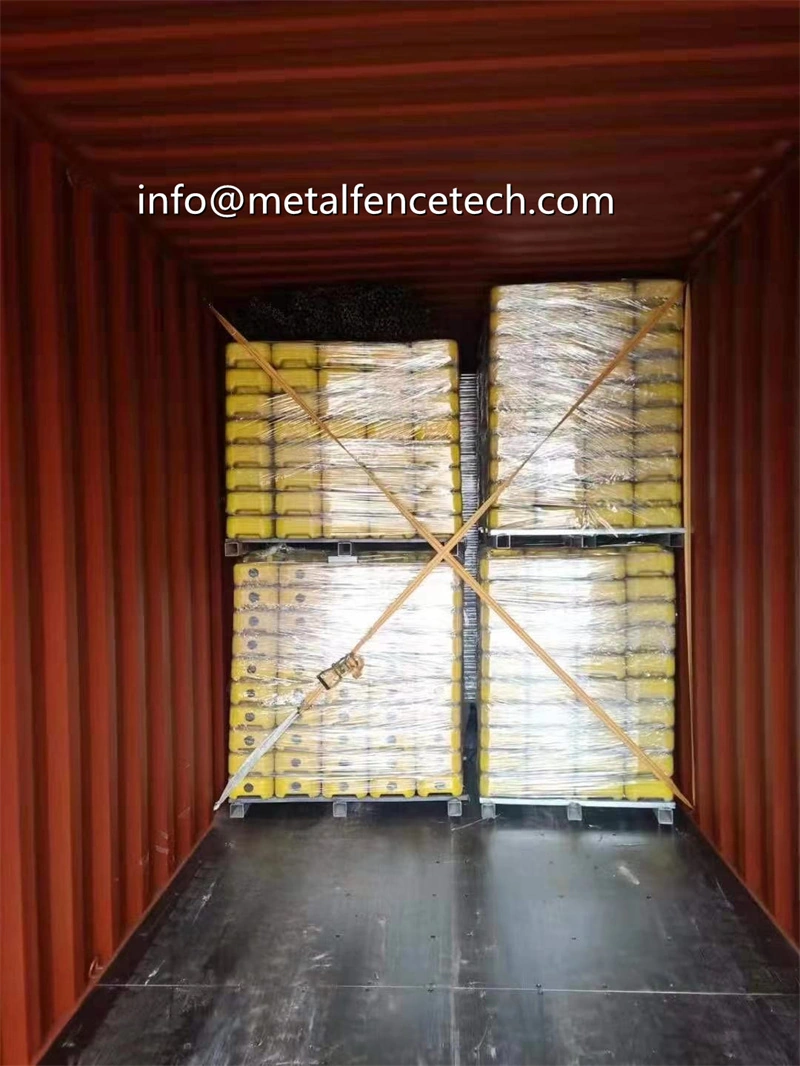 Interior of a red shipping container loaded with four pallets of yellow temporary fence panels wrapped in plastic, secured with cross strapping, showcasing DB Fencing's bulk export of wire mesh fencing products for B2B customers.