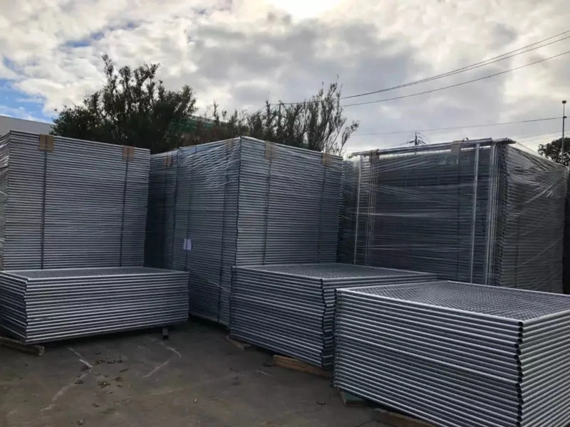 Stacks of hot-dipped galvanized temporary fence panels, bundled and stored on wooden pallets in an outdoor yard, showcasing DB Fencing's bulk-ready, AS 4687-compliant products for construction, event management, and agricultural use.