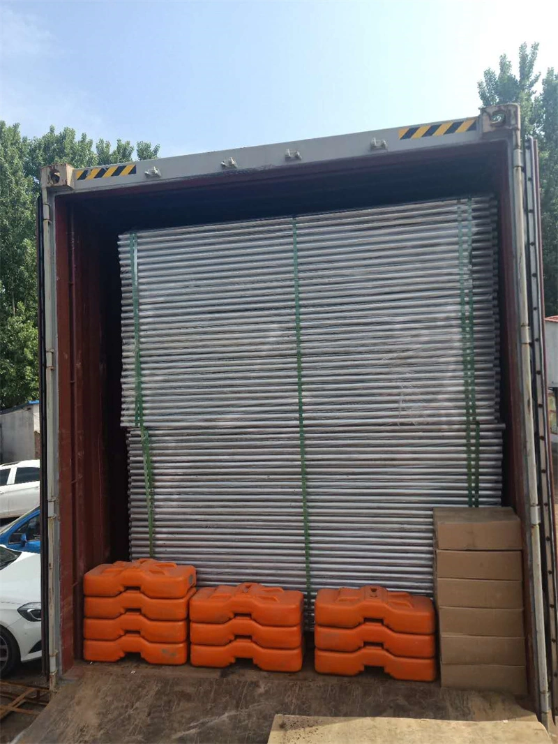 Stacked temporary fence panels secured with green straps and orange plastic feet inside a shipping container, showcasing DB Fencing's export-ready products for construction, event management, and agricultural clients.