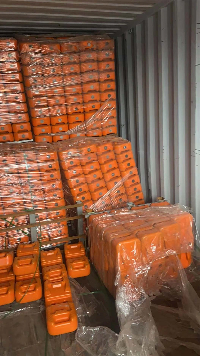 Orange plastic temporary fence feet stacked in pallets and wrapped in plastic inside a freight container, prepared for export to global B2B customers such as construction firms and distributorsmanufactured by DB Fencing, a leading one-stop wire mesh fence supplier with 14 years of export experience.