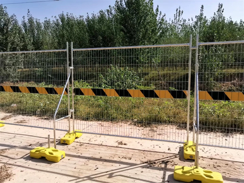 Temporary metal mesh fence with yellow plastic feet, manufactured by DB Fencing (Anping Deban Metal Wire Mesh Products Co., Ltd), designed for construction sites and event crowd control, featuring hot-dipped galvanized finish and compliance with Australian Standards (AS 4687-2022/2007).