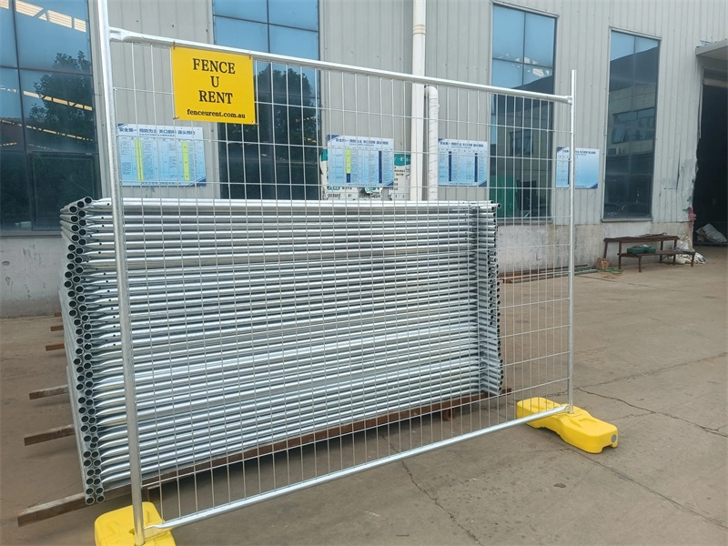 Galvanized temporary mesh fence with yellow plastic feet, manufactured by DB Fencing, a leading wire mesh fence supplier for construction and event management companies, featuring hot-dipped galvanized finish and proprietary plastic feet for durability in outdoor environments.