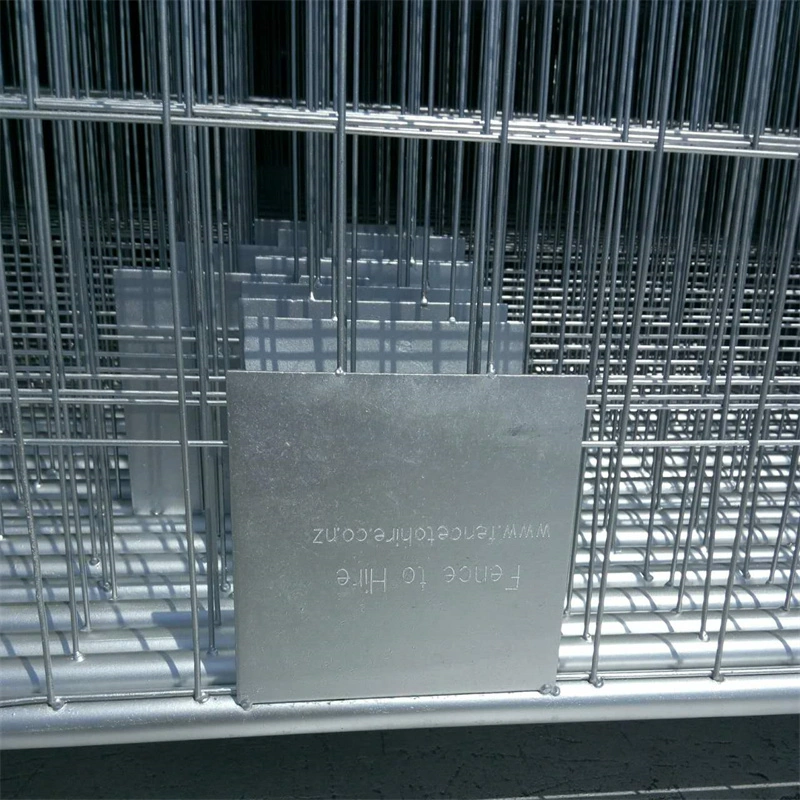 Close-up of galvanized temporary wire mesh fence panels from DB Fencing, a leading one-stop manufacturer and exporter, featuring branded metal plates and stacked inventory that highlights their production capacity and durable, AS-compliant fencing solutions for construction, events, and agriculture.