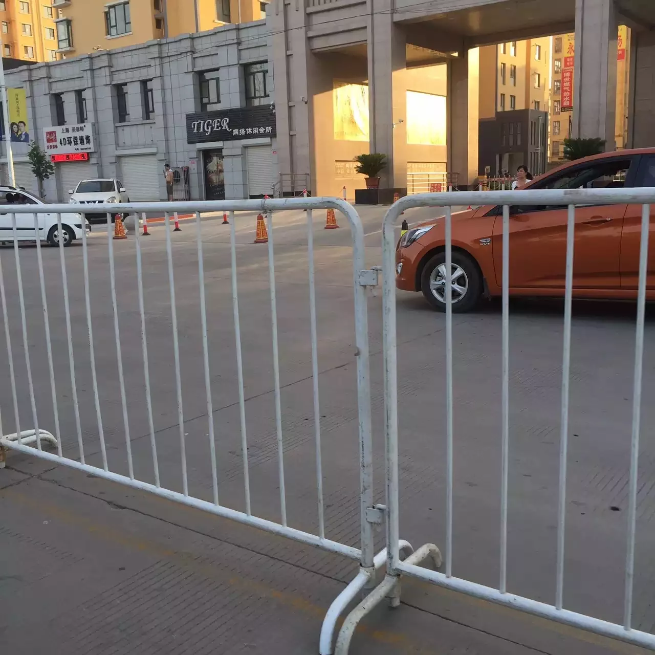 White DB Fencing metal crowd control barriers are securely installed on an urban street, effectively managing public access and enhancing safety. These durable temporary barriers, ideal for events and public gatherings, exemplify DB Fencing's high-quality solutions for crowd control and event perimeter management.