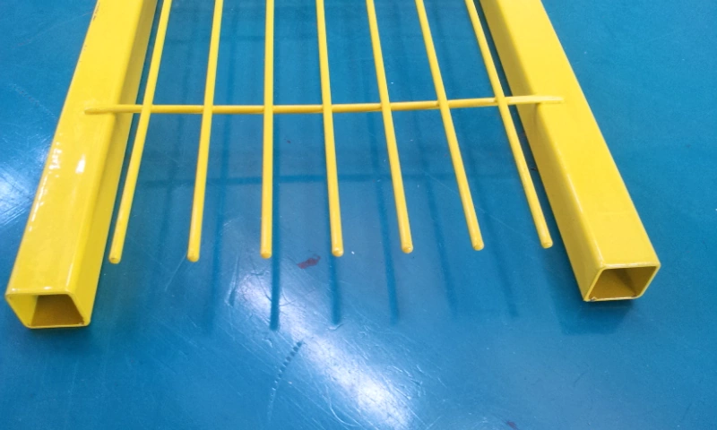 Close-up view of robust, custom-made yellow temporary fence feet designed for Hesco barriers and crowd control barriers. DB Fencing manufactures these specialized base systems to support temporary fencing systems for construction sites and event safety.