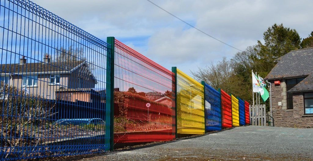 Colourful powder-coated BRC fence panels in blue, red and yellow securing a schoolyard perimeter
