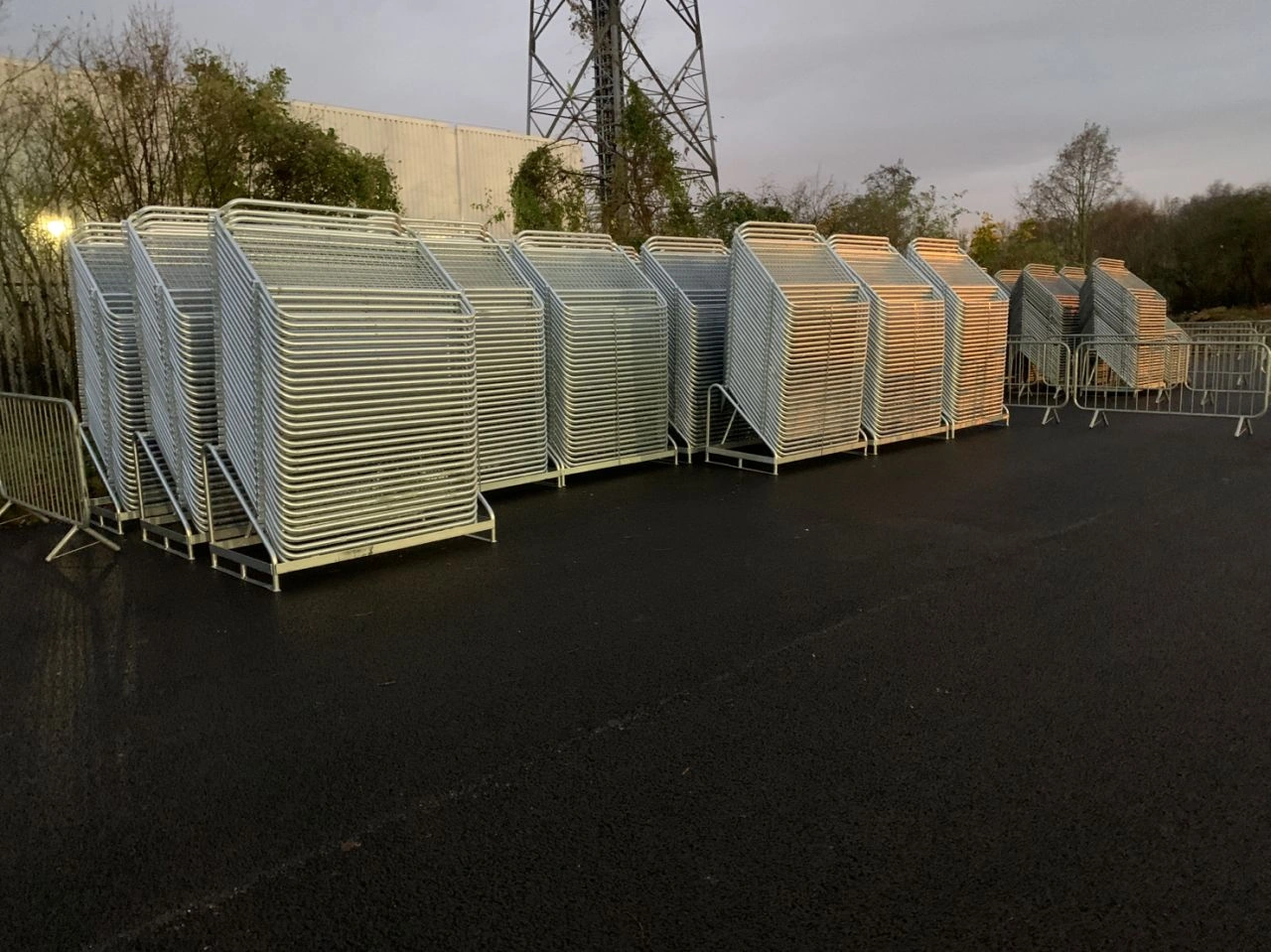 A large inventory of DB Fencing's hot-dipped galvanized Crowd Control Barriers for Events & Public Safety are neatly stacked in an outdoor storage yard, ready for bulk shipping to event management companies and distributors. These durable, AS 4687-compliant barriers showcase our capacity as a leading wire mesh fence manufacturer and exporter from Anping, China.
