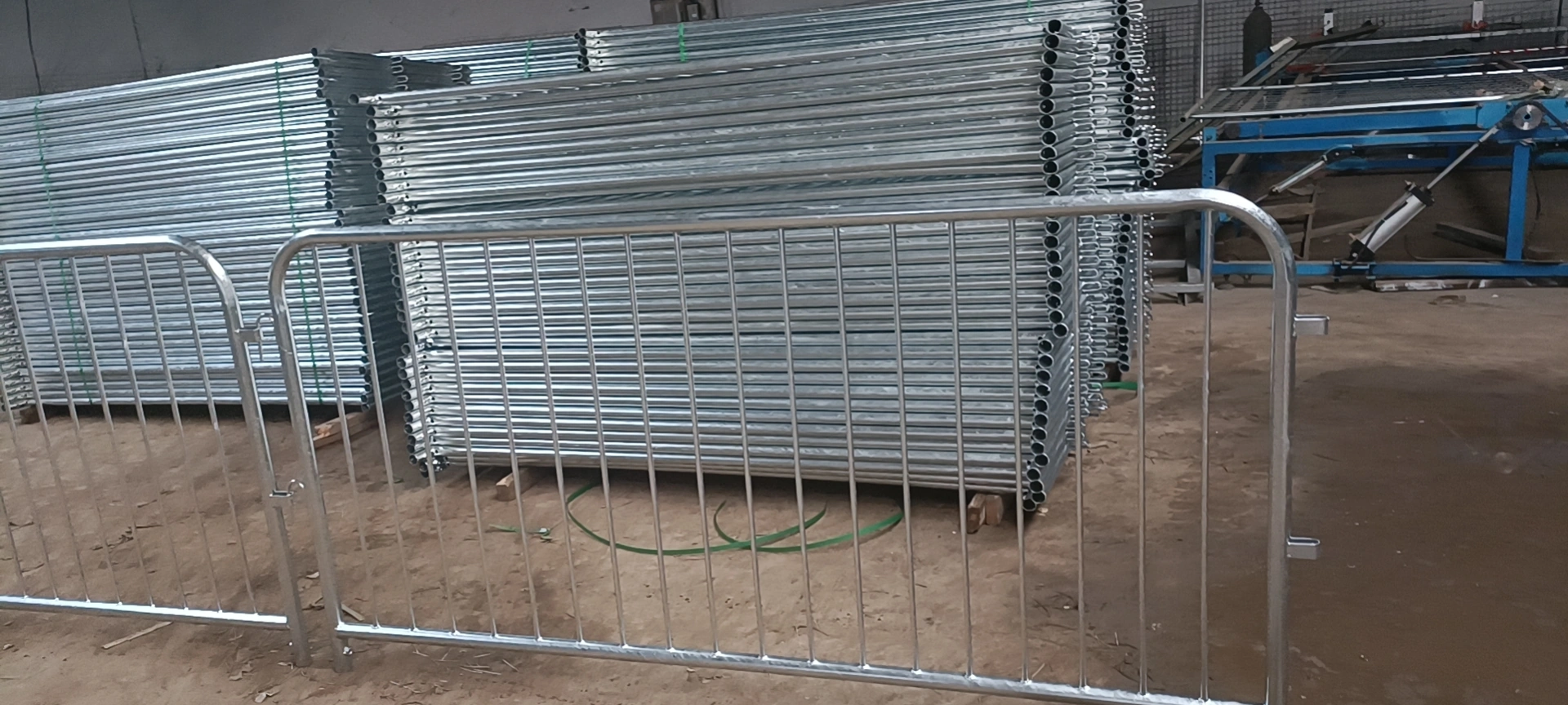A warehouse view displaying large stacks of DB Fencing's hot-dipped galvanized crowd control barriers, showcasing our manufacturing capacity and readiness for bulk export. These durable, Australian-standard compliant barriers are ideal for event management companies and public safety needs, available with flexible MOQ.