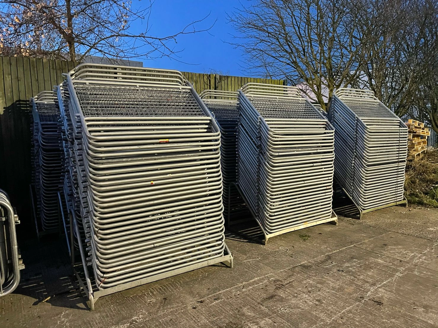 Multiple stacks of robust, hot-dipped galvanized crowd control barriers manufactured by Anping Deban Metal Wire Mesh Products Co., Ltd., neatly stored and ready for bulk export. These durable crowd control barriers are engineered for effective event perimeter management and public safety, reflecting our factory-direct manufacturing and compliance with B2B standards for event management companies.