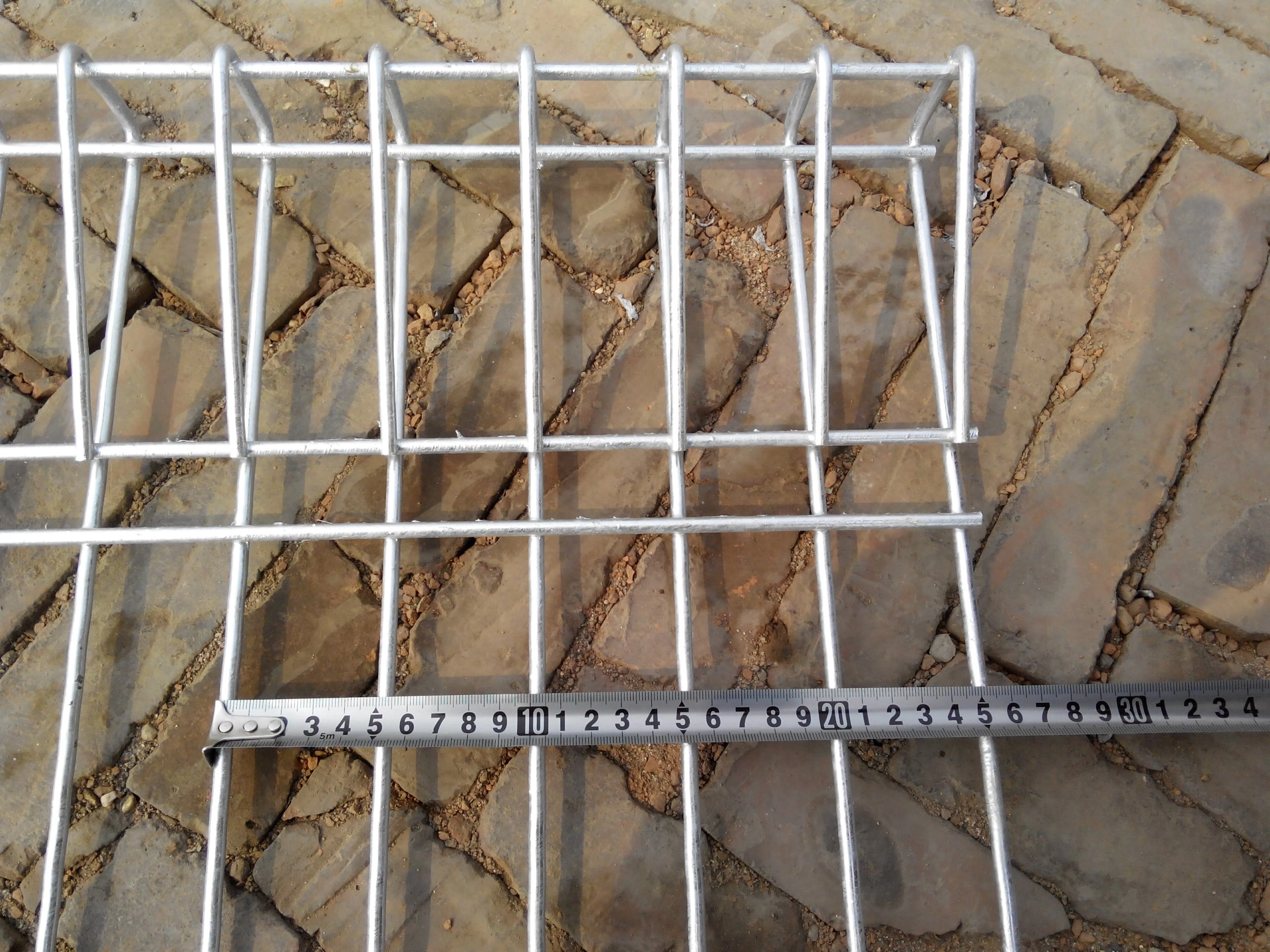 A detailed view of a hot-dipped galvanized BRC wire mesh fence panel from Anping Deban Metal Wire Mesh Products Co., Ltd (DB Fencing), with a measuring tape displaying dimensions. This robust BRC fencing highlights DB Fencing's commitment to durability and compliance with Australian Standard AS 4687 for global B2B clients.