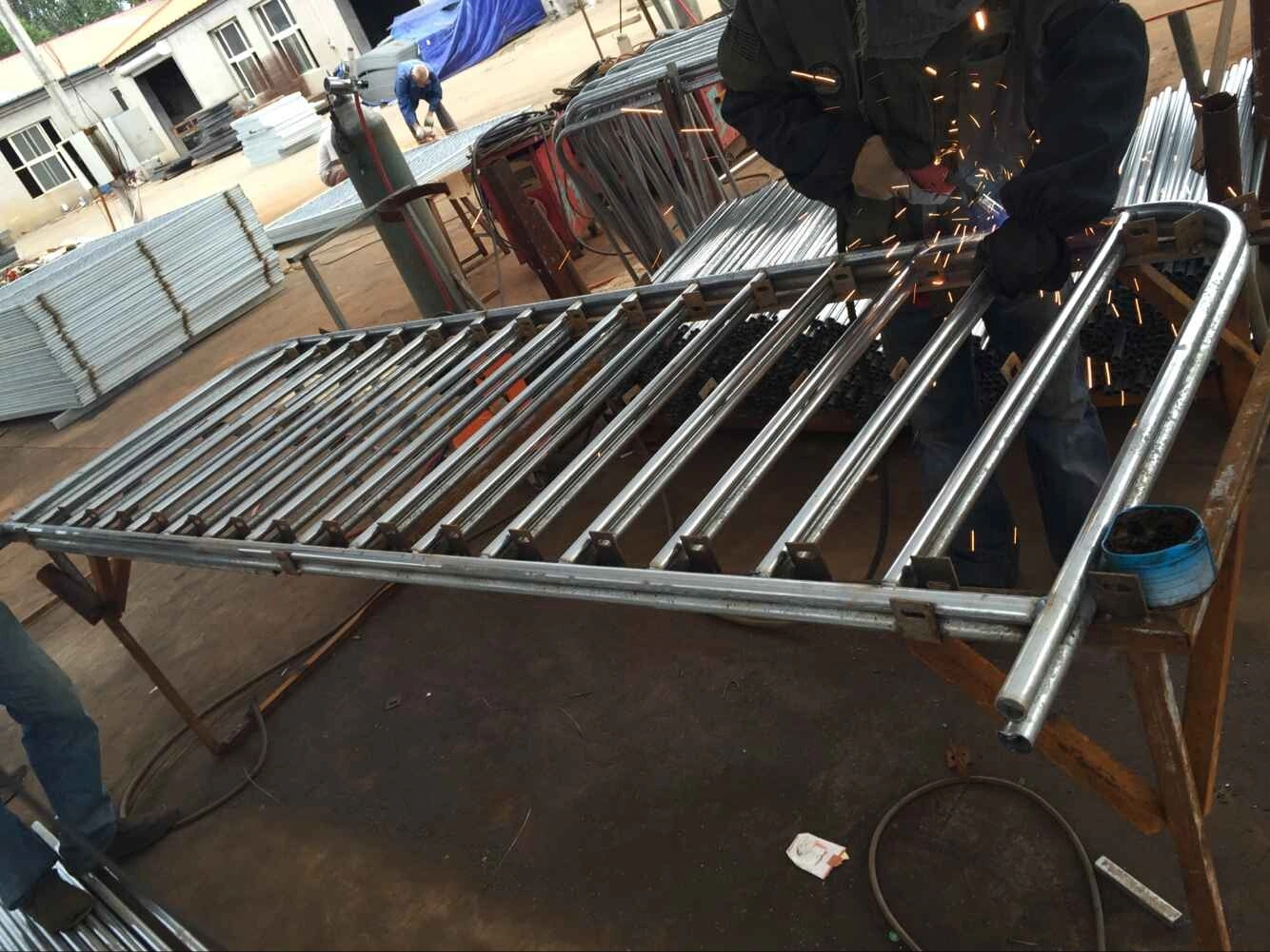 Anping Deban Metal Wire Mesh Products (DB Fencing) worker meticulously grinds a section of a galvanized steel crowd control barrier, demonstrating our commitment to quality fabrication. This scene highlights our advanced manufacturing capabilities for robust Crowd Control Barriers for Events & Public Safety, ensuring durable solutions for our global clients, especially in Australia, New Zealand, and North America.