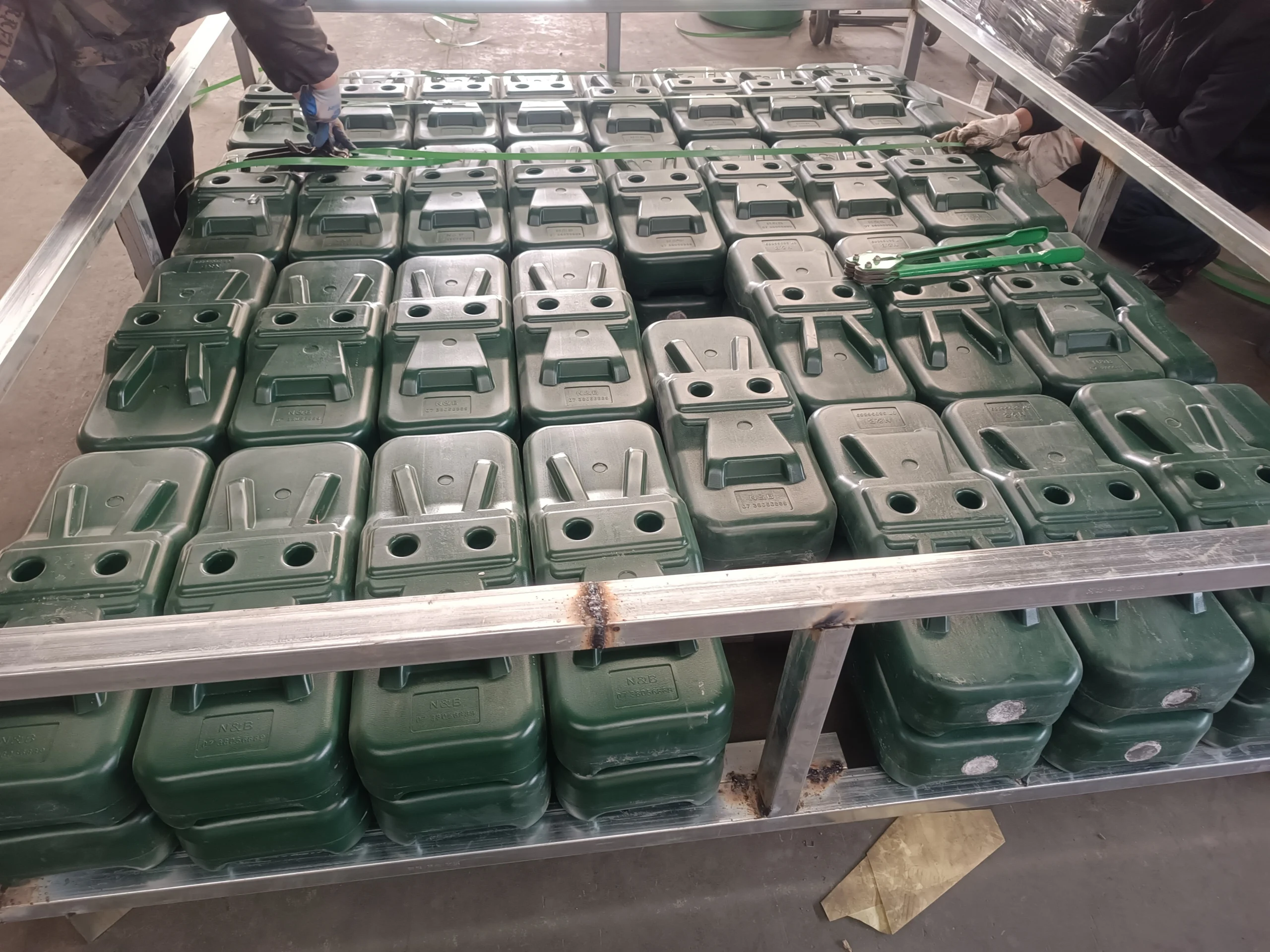 A comprehensive view of numerous dark green plastic temporary fence feet and base systems stacked for packaging or shipment at DB Fencing's state-of-the-art facility in Anping. As the only supplier in Anping with its own plastic feet machine, DB Fencing proudly produces these essential Temporary Fence Feet & Base Systems, ensuring compliance with Australian standards for B2B distributors and construction firms globally.