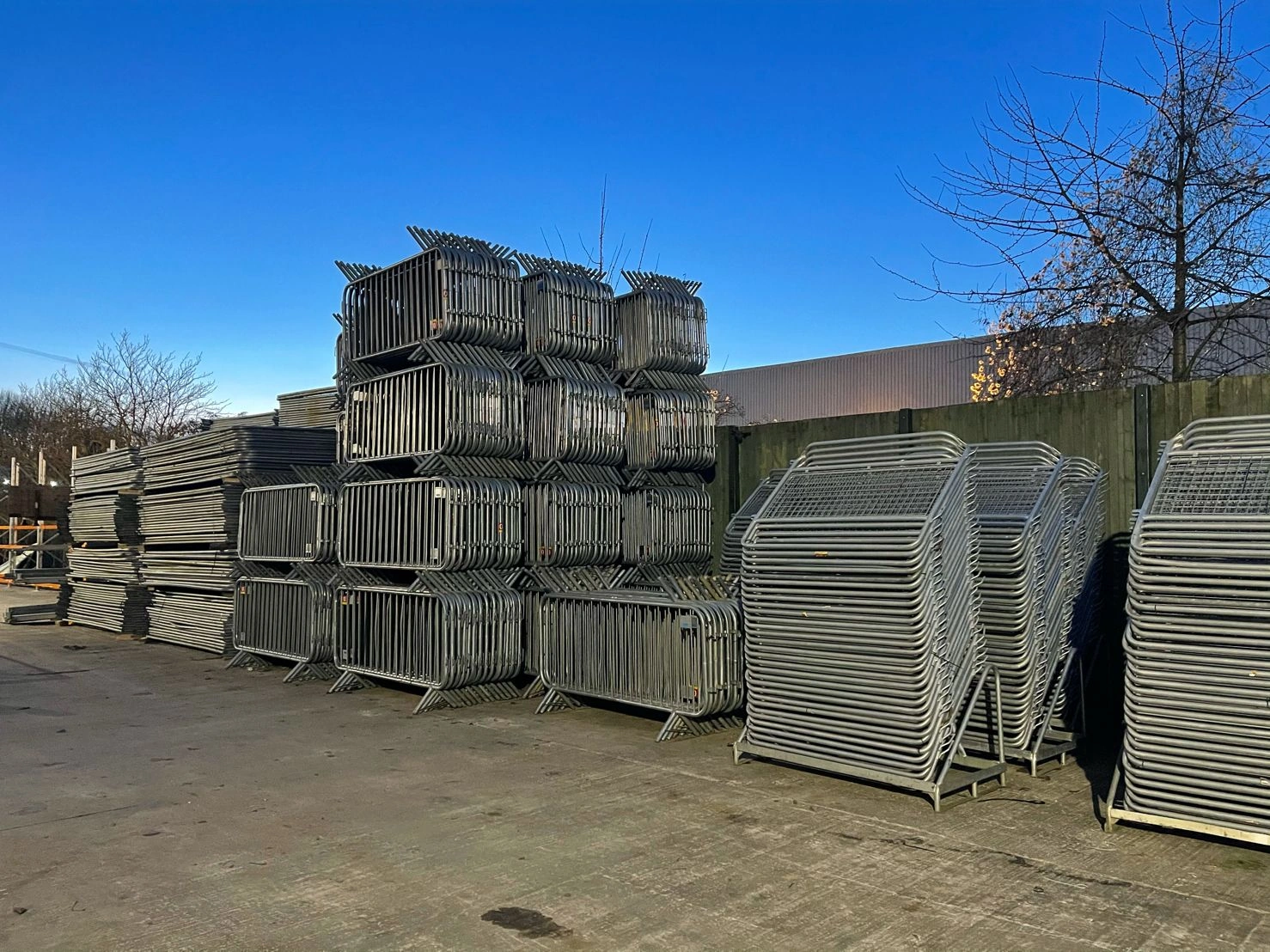 A massive inventory of hot-dipped galvanized crowd control barriers, precisely stacked for efficient storage and distribution at the Anping Deban Metal Wire Mesh Products factory. These durable barriers are manufactured to meet high standards, ready to serve event management companies and global distributors for effective crowd control and public safety.