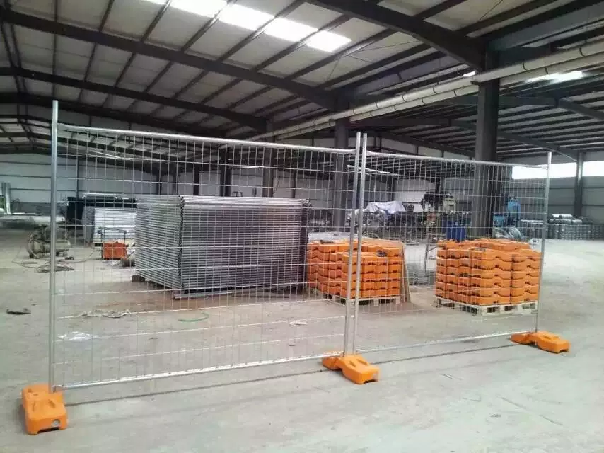 Inside DB Fencing's Anping factory, showcasing durable temporary fence feet and base systems, manufactured using their proprietary plastic feet machine. Stacked AS 4687-compliant galvanized temporary fencing panels are also visible, demonstrating DB Fencing's production strength as a top B2B wire mesh fence manufacturer for construction and event security.