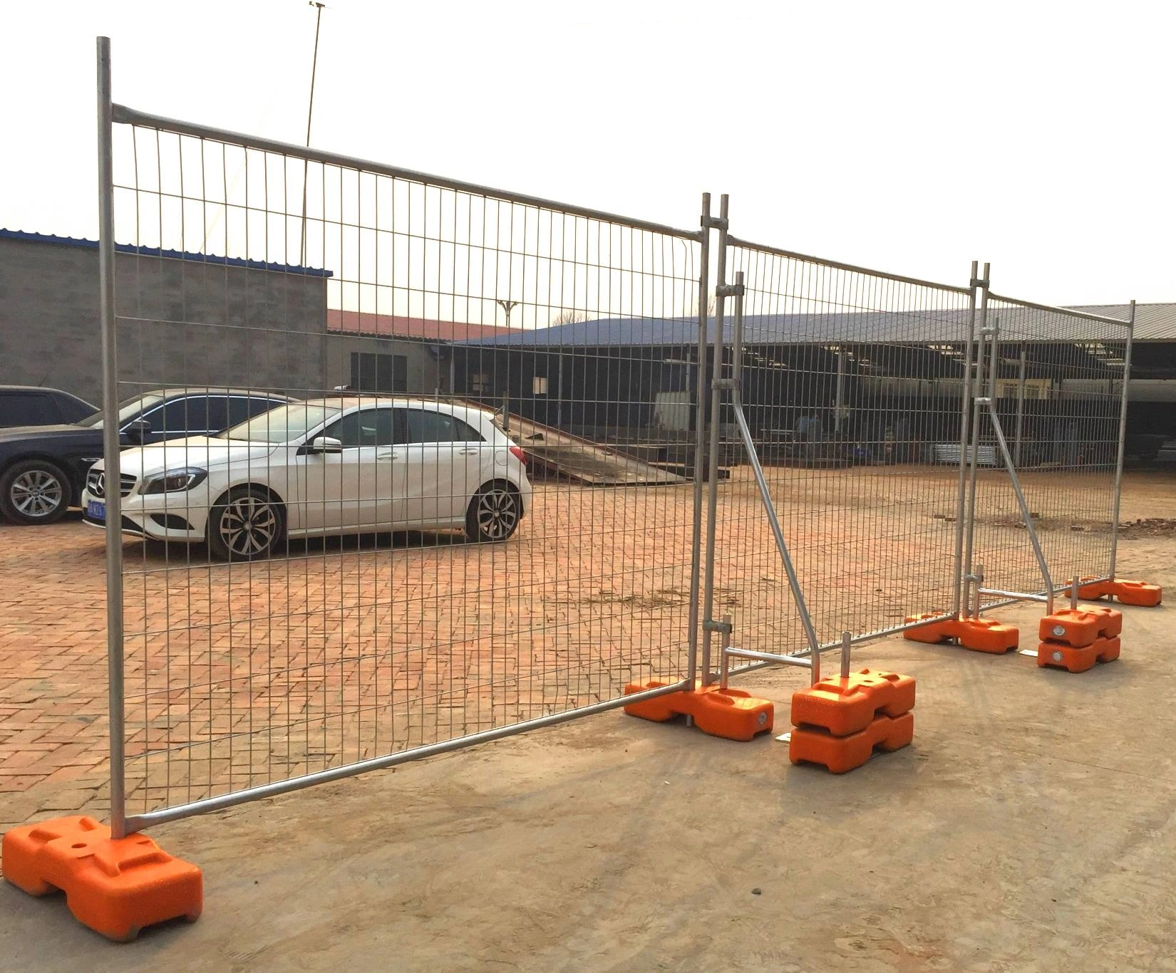 Visually demonstrating DB Fencing's robust temporary fencing panels, firmly anchored by bright orange plastic Temporary Fence Feet & Base Systems. These durable, self-produced bases ensure superior stability and compliance for secure construction site perimeters, reflecting our commitment to quality and Australian Standard requirements.