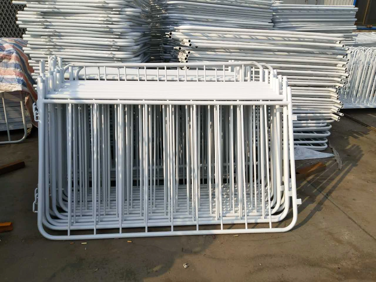 Large stacks of newly manufactured, white powder-coated steel crowd control barriers from DB Fencing, China's leading exporter. These durable temporary event barriers, suitable for events and public safety, are hot-dip galvanized to exceed AS 4687 standards for harsh environments, ideal for event management companies and global distributors seeking factory-direct solutions.