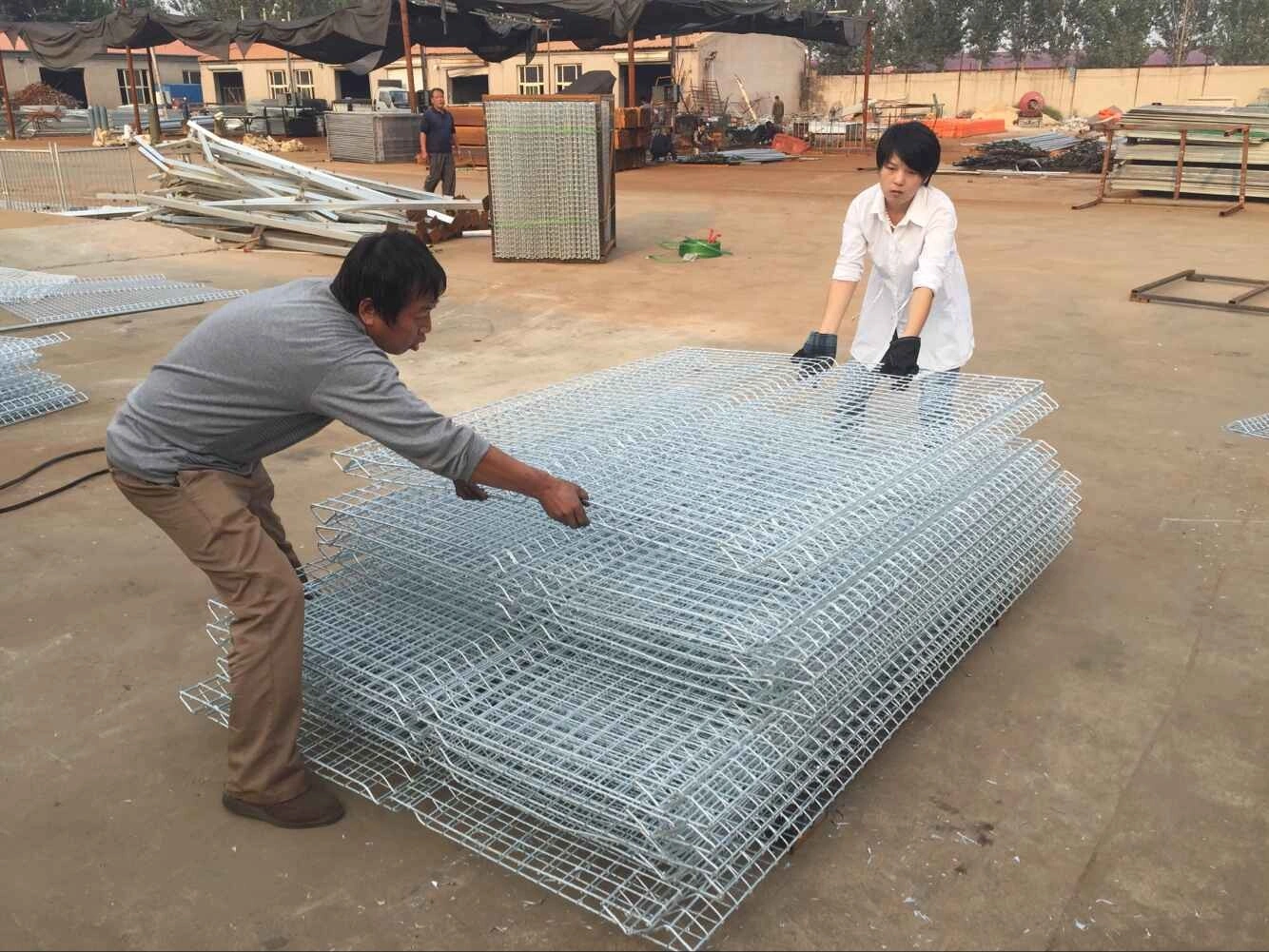 DB Fencing workers are carefully stacking freshly produced hot-dipped galvanized wire mesh fencing panels at our Anping manufacturing facility. This image showcases the hands-on quality control and preparation of our durable wire mesh fencing, ready for bulk export to construction, event, and agricultural distributors worldwide.