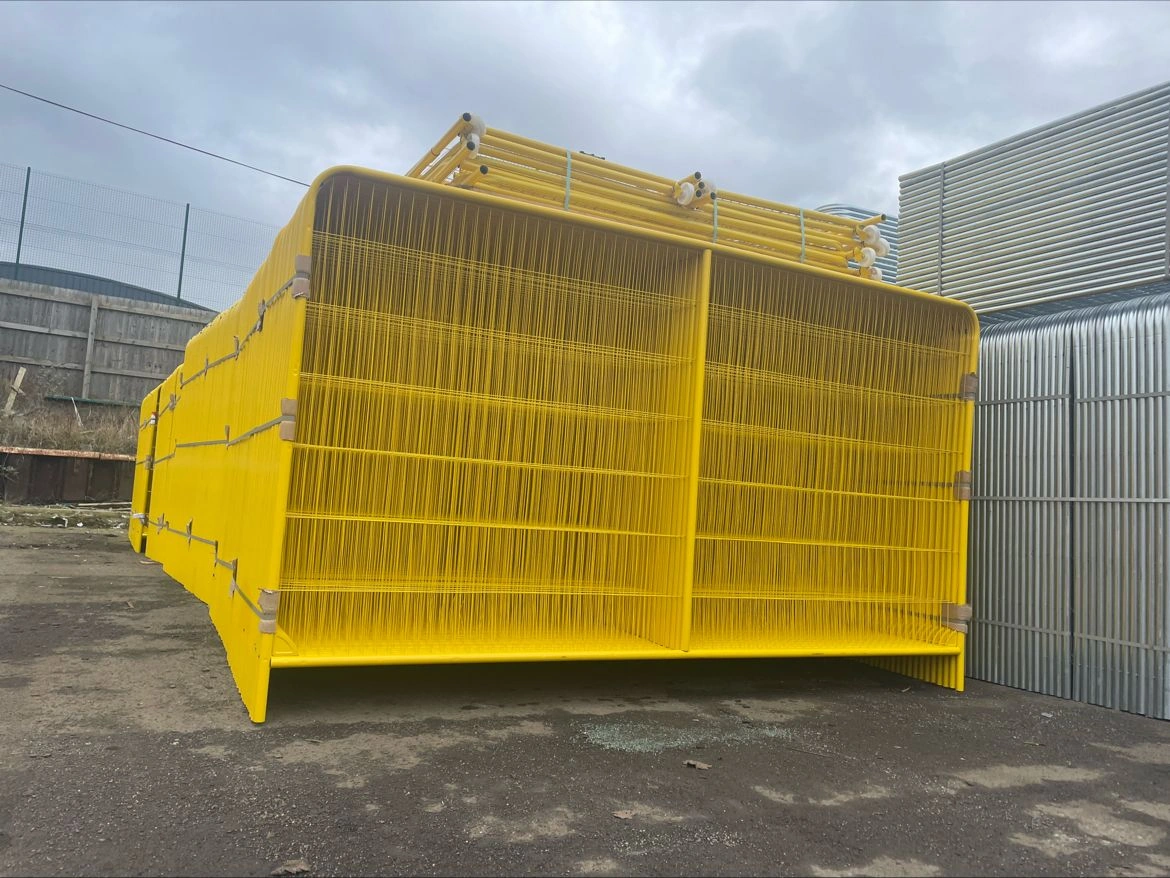 A large stack of vibrant yellow temporary fencing systems for construction, manufactured by Anping Deban Metal Wire Mesh Products Co., Ltd (DB Fencing), is shown in bulk, highlighting our leading 'one-stop' production capability. These hot-dipped galvanized panels, compliant with Australian Standard AS 4687-2022/2007, are prepared for global export to construction and civil engineering firms.