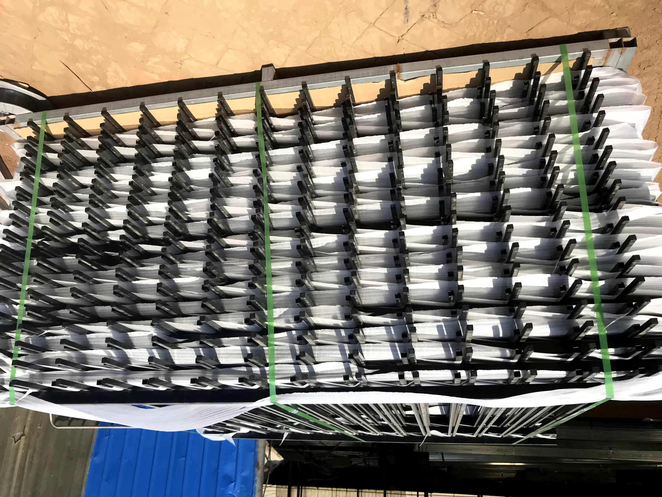 High-capacity manufacturing shot showing stacks of hot-dipped galvanized steel security fencing panels ready for shipment, manufactured by DB Fencing.