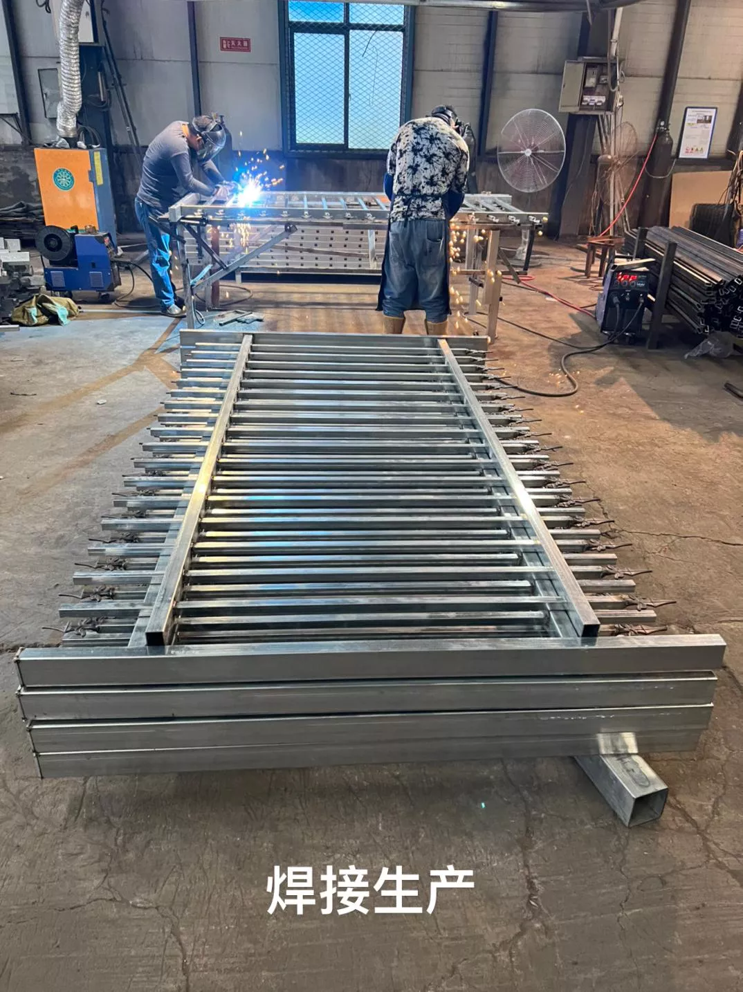 DB Fencing operates a robust steel security fencing production line in Anping. Workers are shown manufacturing heavy-duty welded steel mesh panels using our specialized 2,000-set weekly capacity equipment.