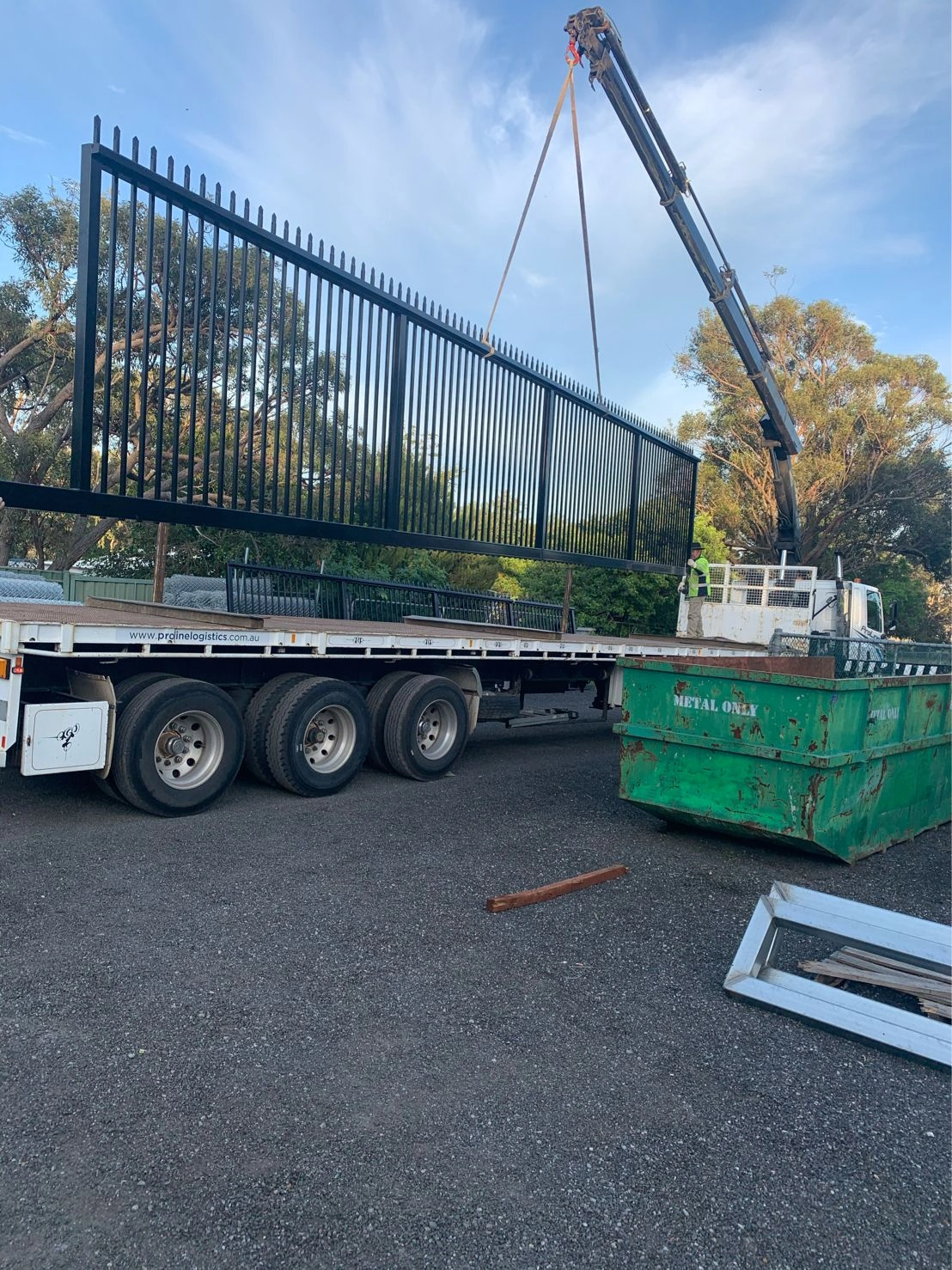 DB Fencing's permanent steel security fencing solutions are being carefully loaded onto a flatbed truck for international shipping. This durable black powder-coated perimeter barrier is manufactured to AS 4687 standards for the construction and industrial markets.