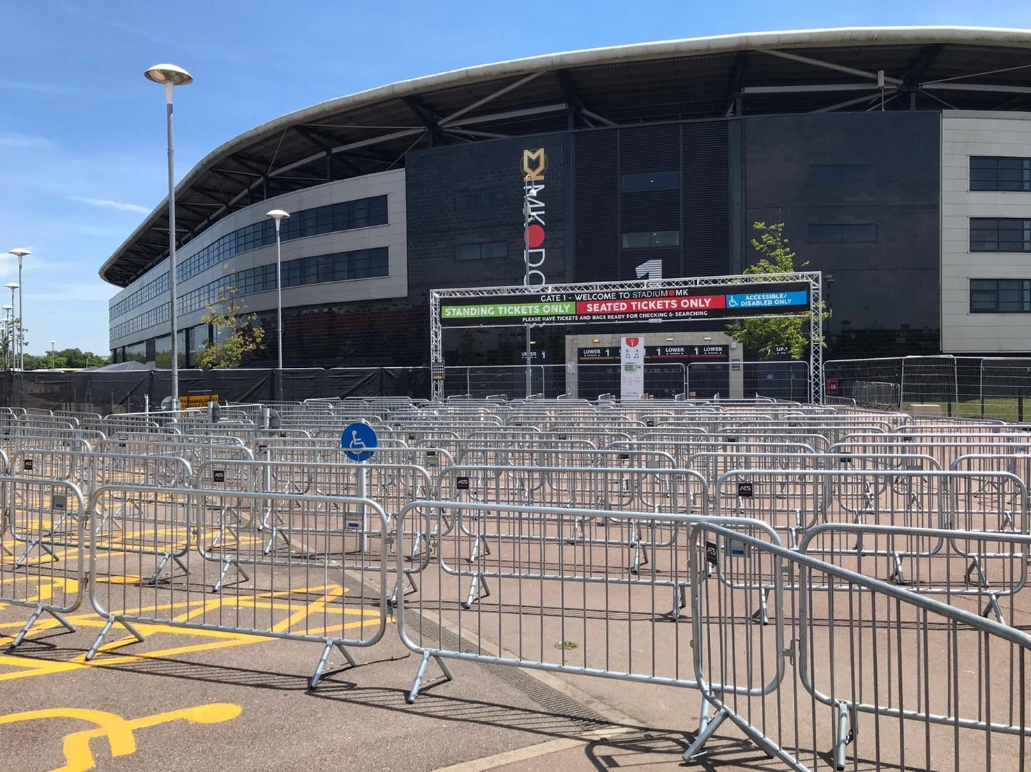 A large setup of DB Fencing's hot-dipped galvanized steel crowd control barriers directs attendees at a stadium entrance for a major event. These robust, AS 4687-2022/2007 compliant crowd control barriers manage queues for standing, seated, and accessible tickets, illustrating DB Fencing's commitment to event perimeter management and public safety solutions.