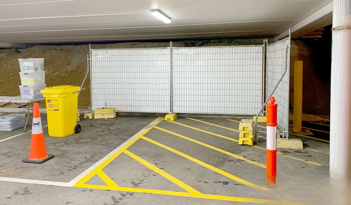 High-quality temporary fencing systems, crucial for construction sites and temporary facilities, are expertly set up in an underground parking garage, forming a secure perimeter. This professional wire mesh barrier, manufactured by DB Fencing, utilizes sturdy yellow base feet for stability, demonstrating reliable site demarcation and safety solutions.