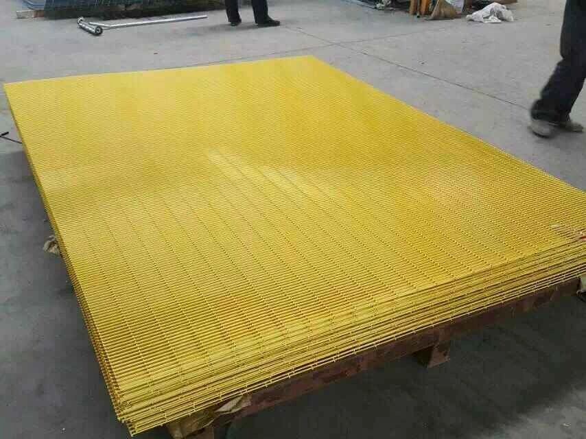 Stacks of bright yellow powder-coated temporary fencing panels at the DB Fencing facility in Anping, showcasing heavy-duty wire mesh solutions designed for secure construction site perimeters.